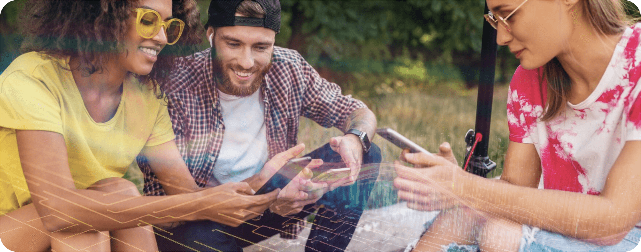 A group of happy young people are sitting and looking at their smartphones.