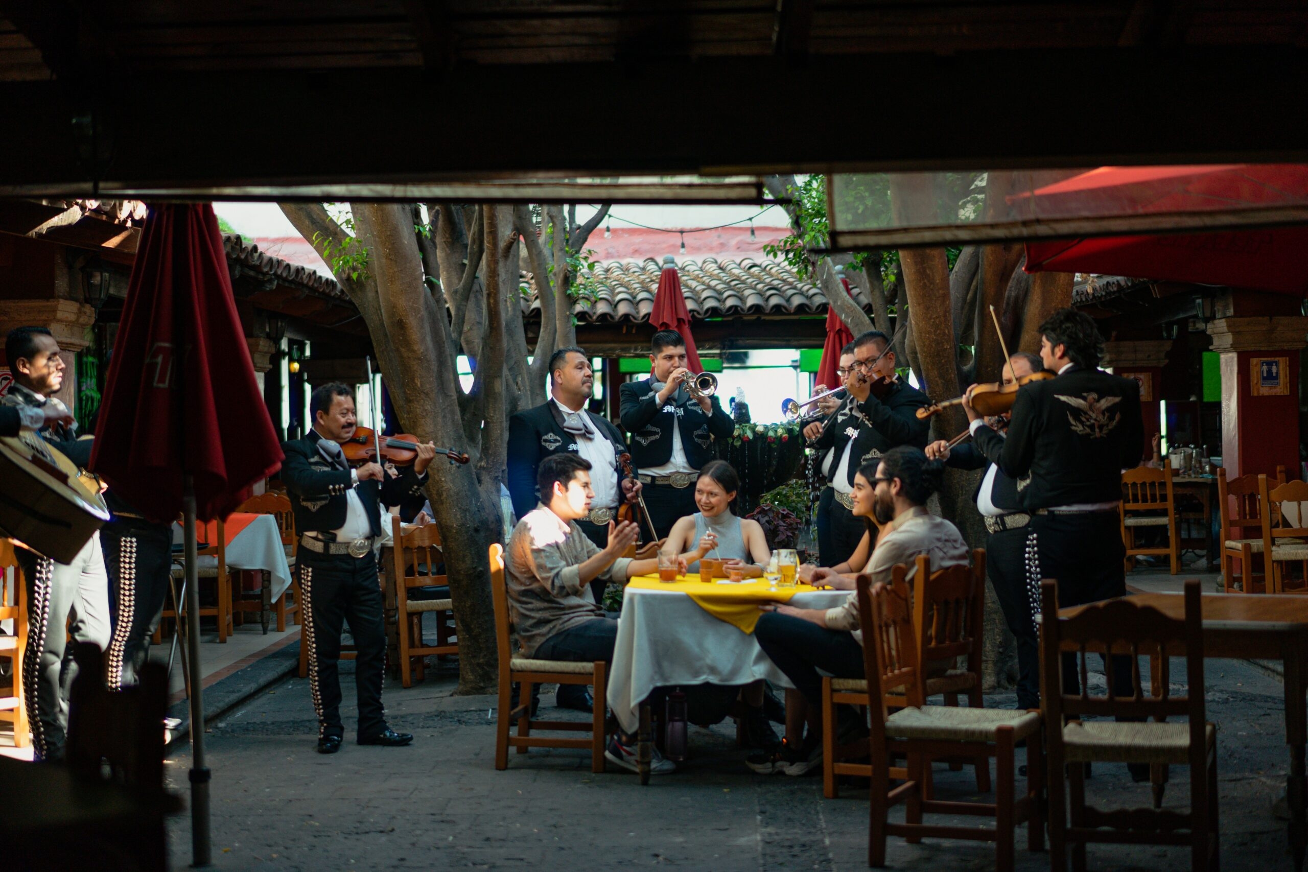 A band is playing music, while four people are drinking.