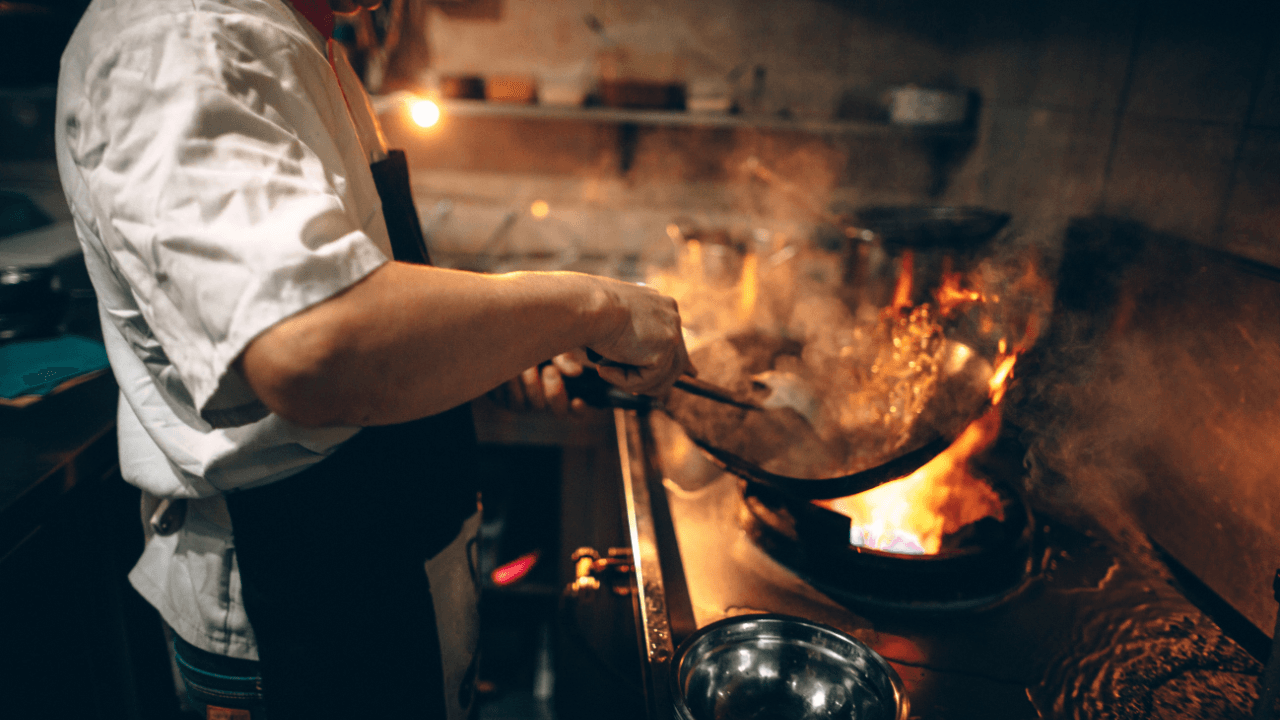 A cook is making a dish.