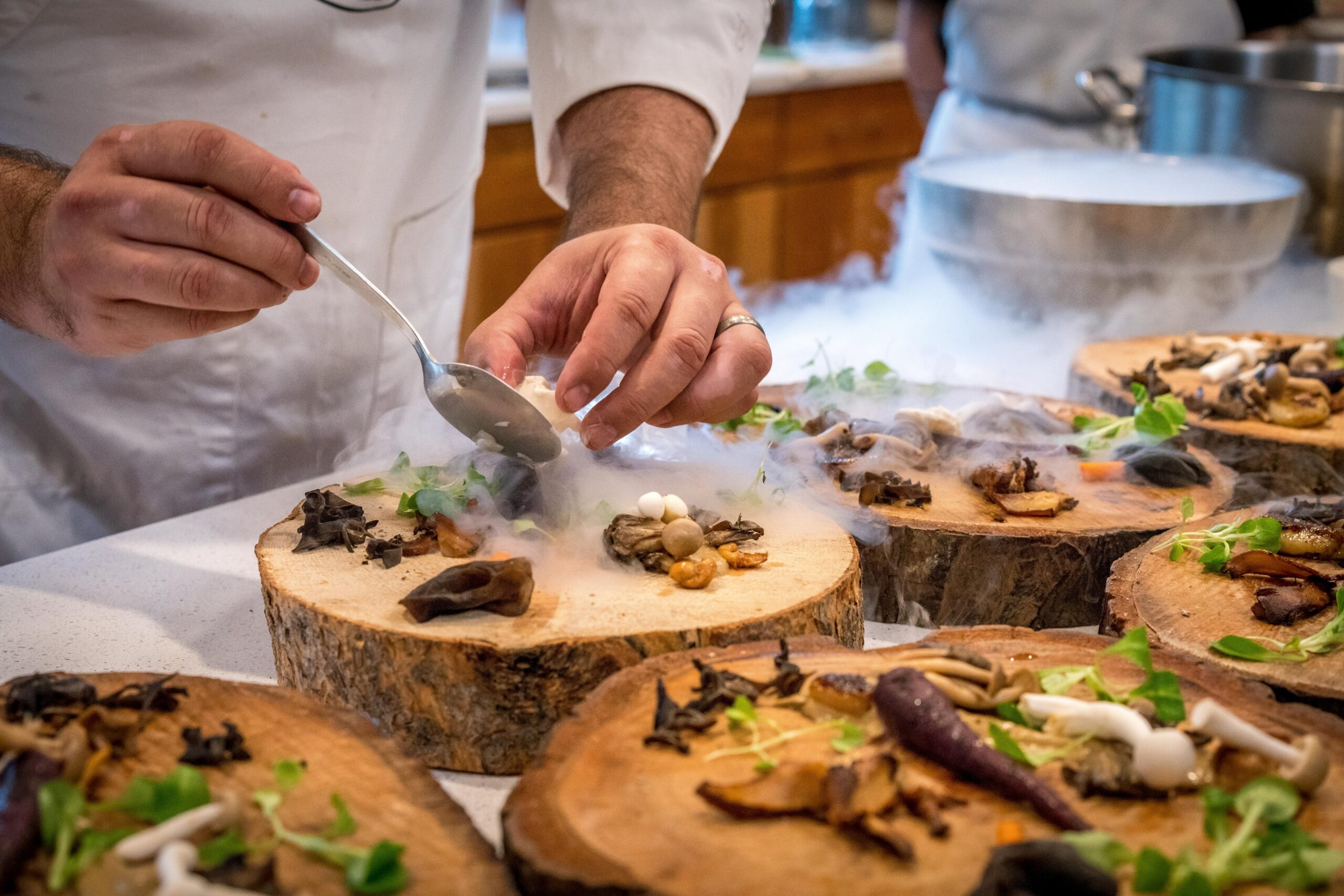 A cook is working on the dish.