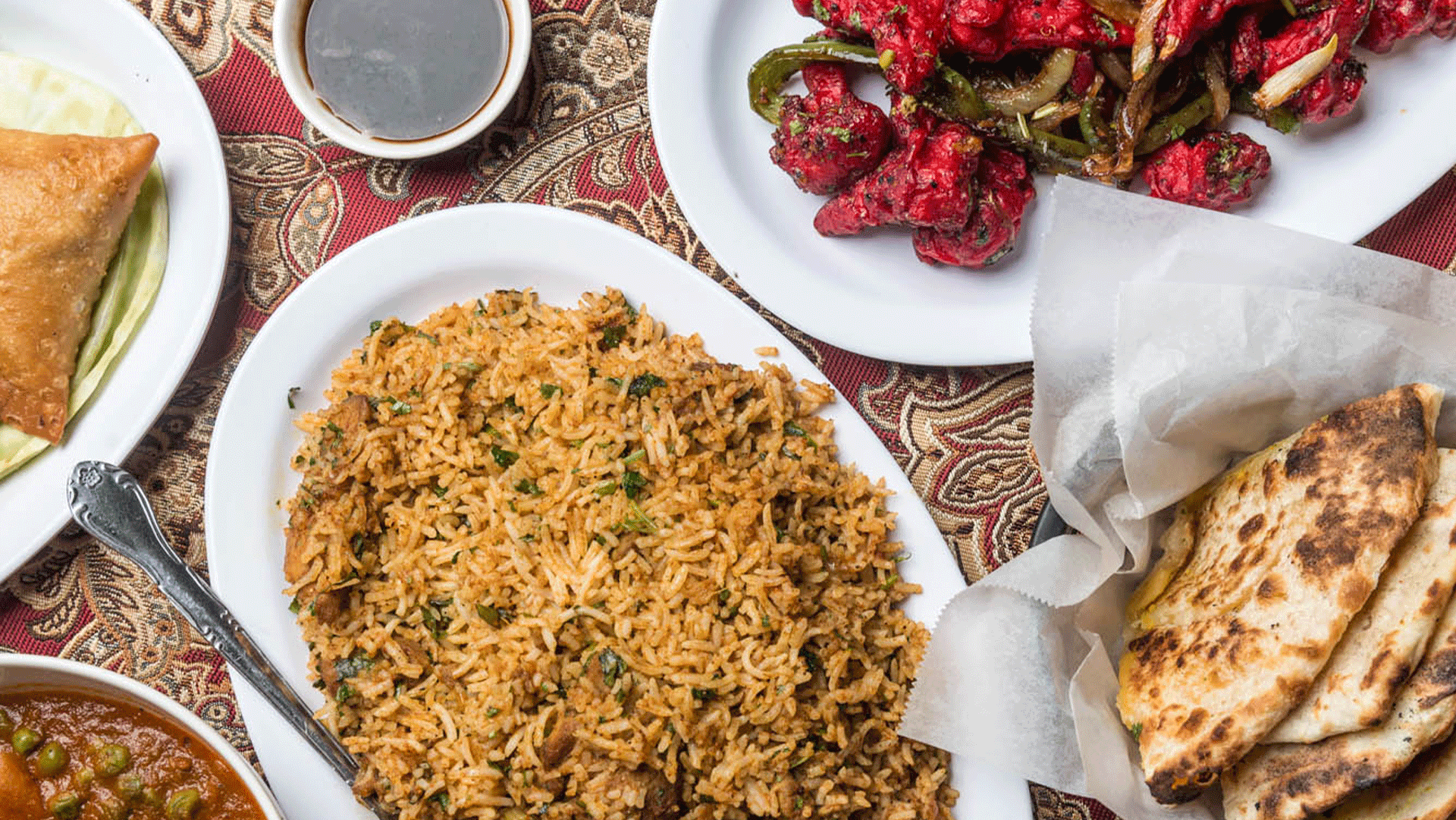 A roasted rice is placed on the table with pieces of bread and vegetables.