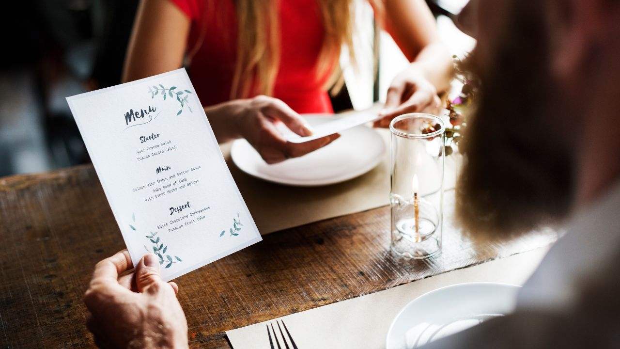 A couple is looking at the menu in the restaurant.