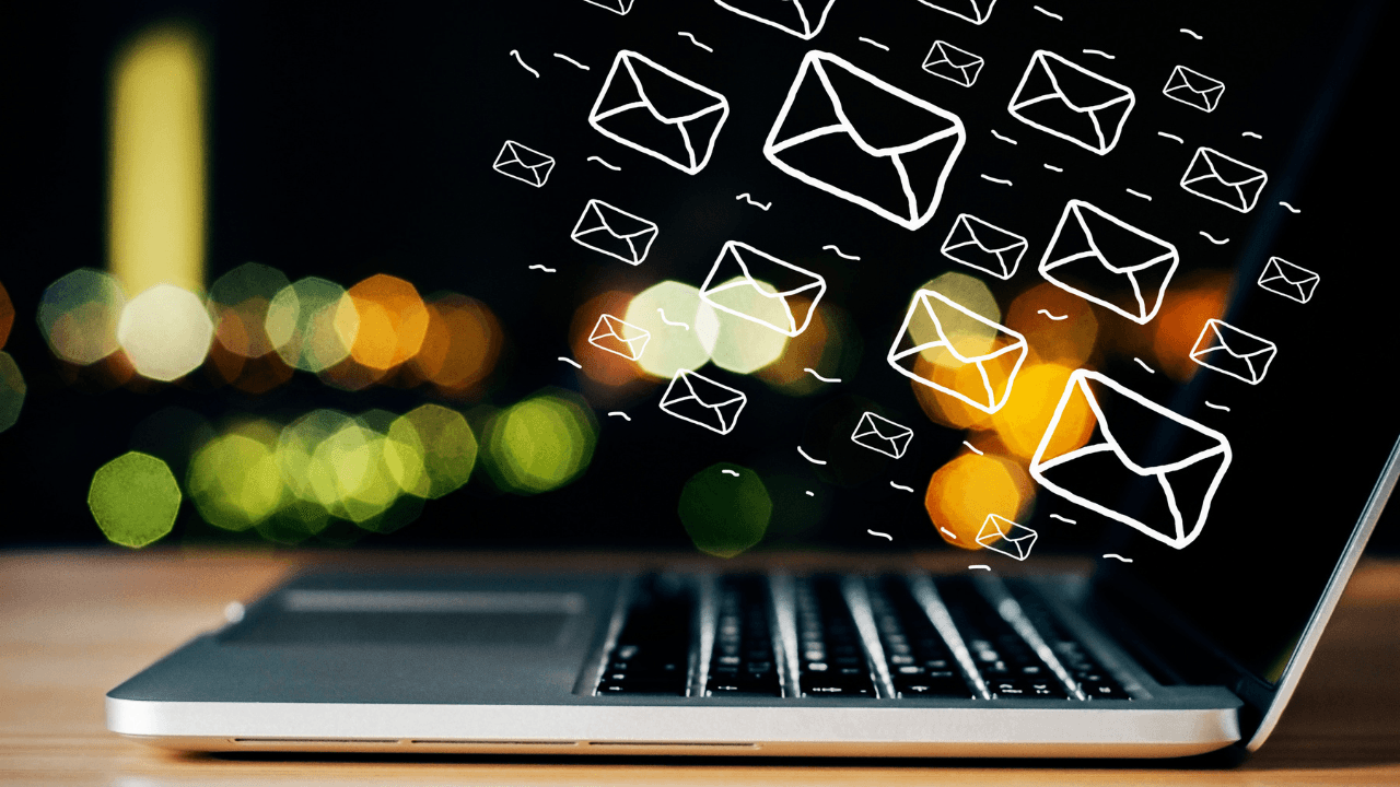 A laptop is placed on the table and various icons of email are shown on it.