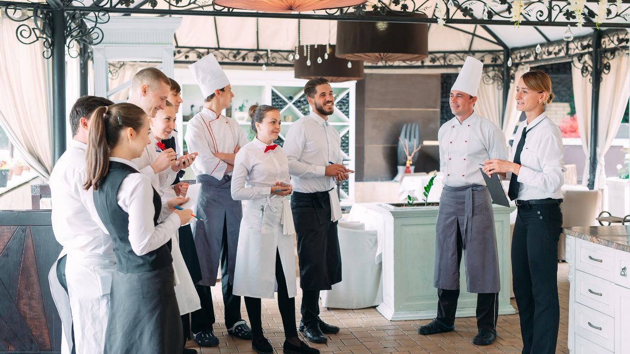 A restaurant staff have a discussion with their manager.