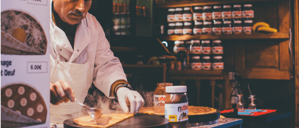 A cook is making a pancake with Nutella.