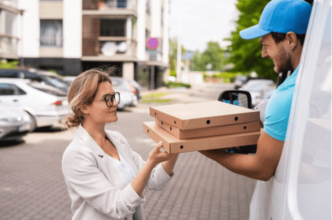 A delivery guy gives pizzas to a girl.