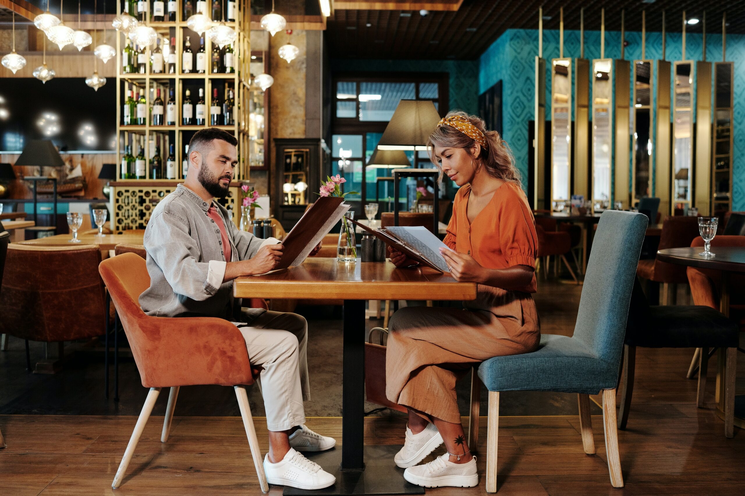 A couple is looking at the restaurant menu.