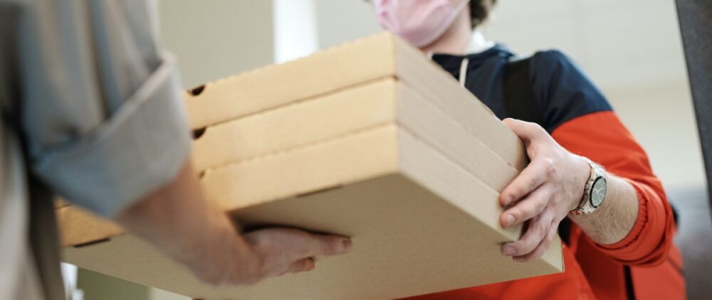 A delivery guy gives three pizzas.