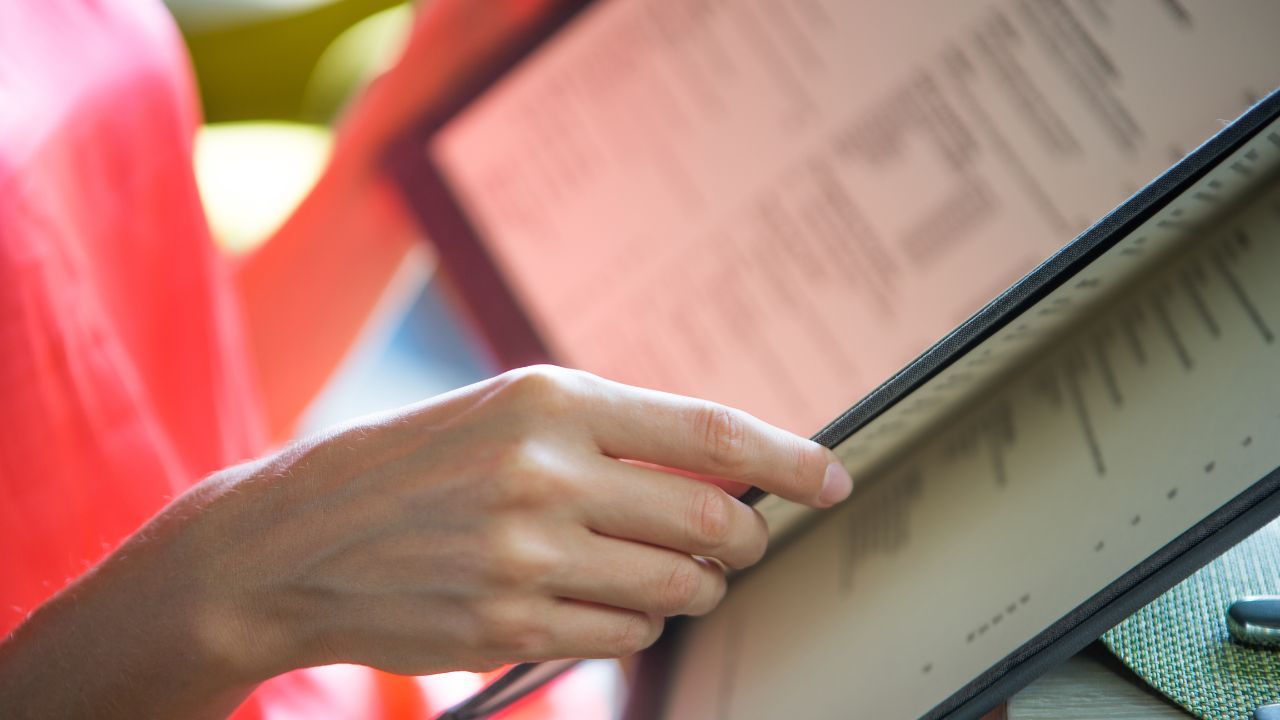 A woman looks at the restaurant menu.