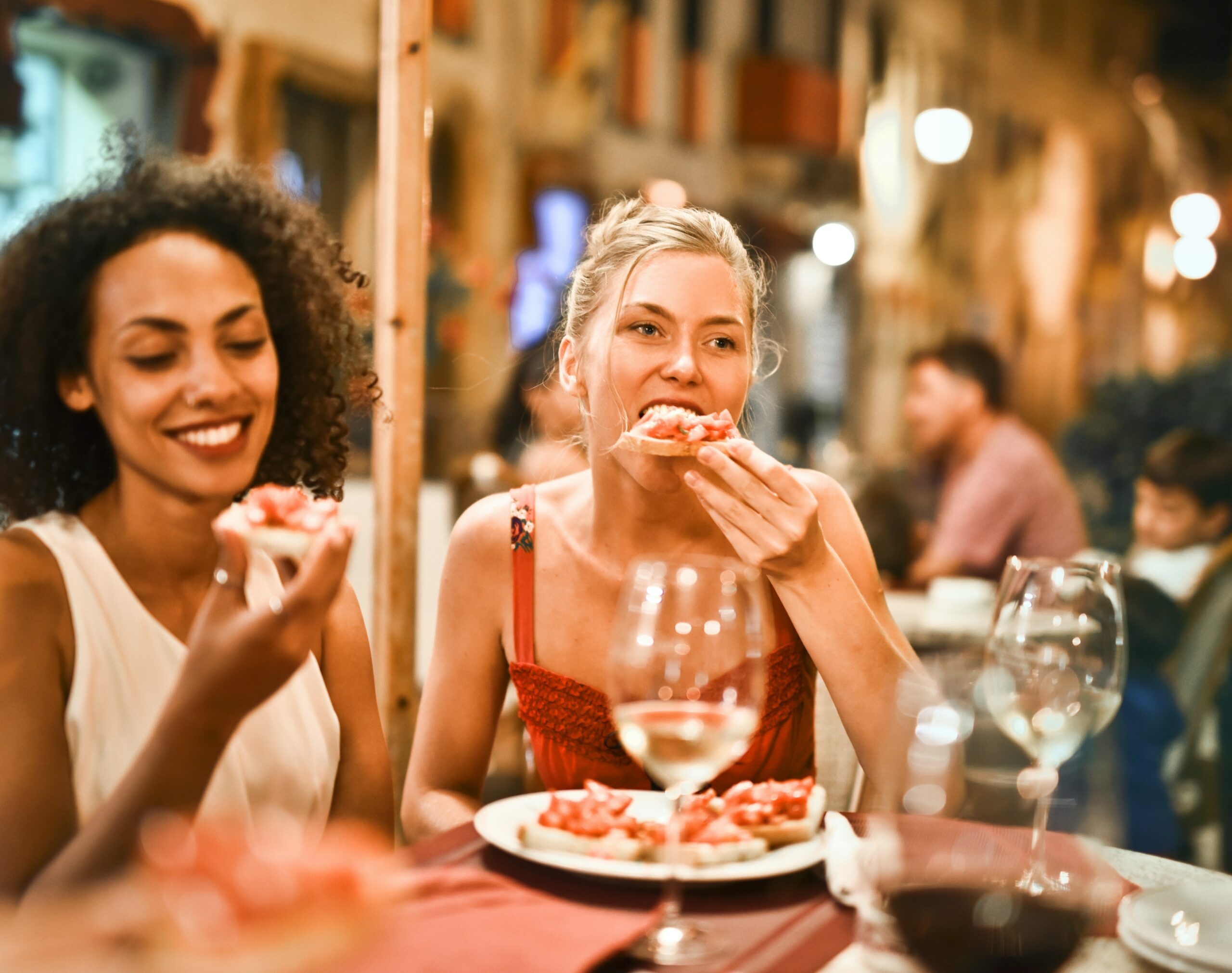 A girl eats a bruschetta.